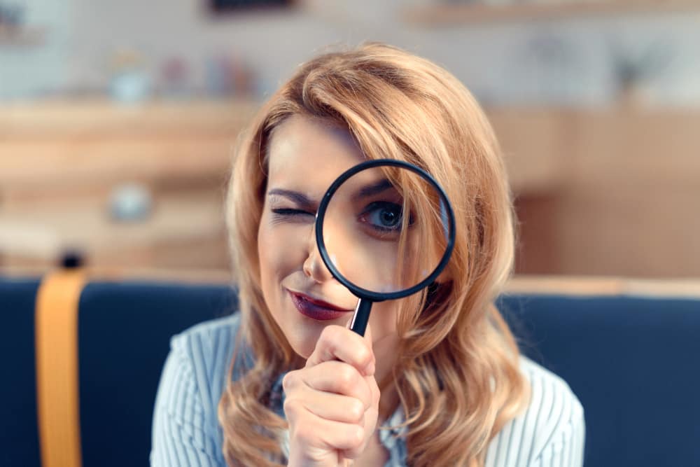 woman looking through magnifying glass