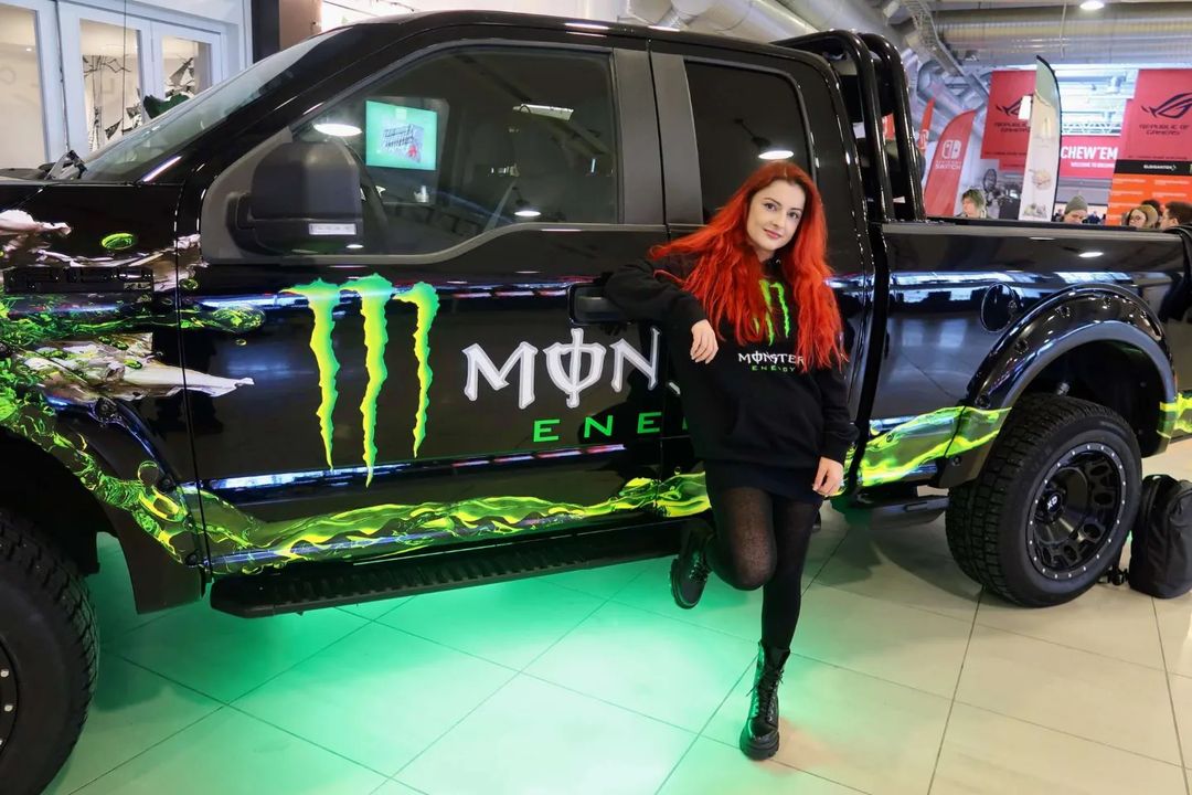 AnnieFuchsia beside a pickup truck with the Monster Energy Drink logo
